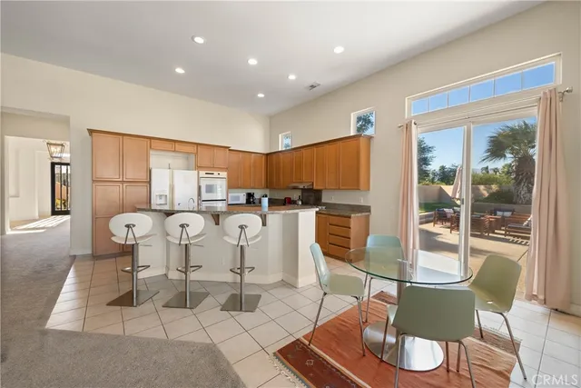 a view of a dining room with furniture a kitchen and chandelier