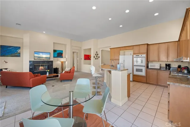 a living room with furniture a fireplace and kitchen view