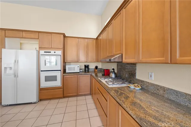 a kitchen with stainless steel appliances granite countertop a refrigerator sink and cabinets