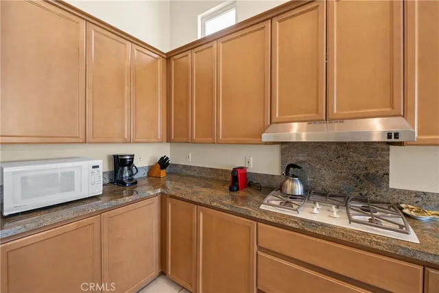 a kitchen with stainless steel appliances granite countertop a sink a refrigerator and cabinets
