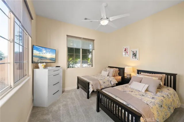 a bedroom with two beds and a large window