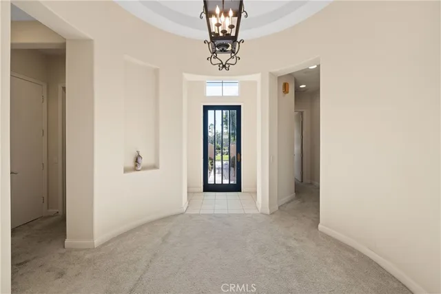 a view of a hallway with windows and chandelier