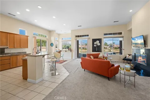 a living room with couches and kitchen view with wooden floor