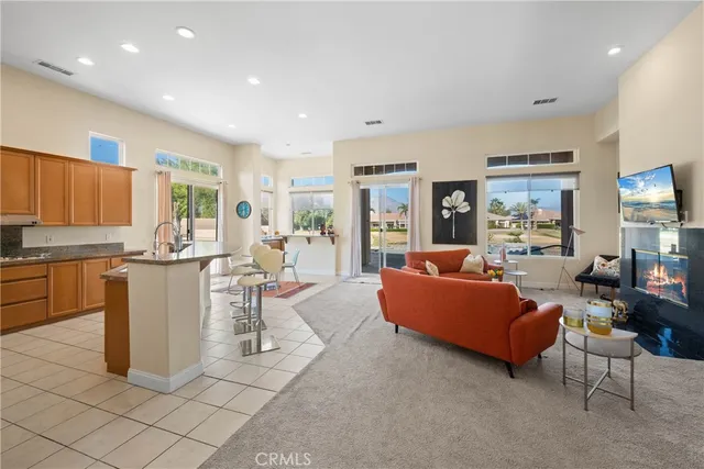 a living room with couches and kitchen view with wooden floor