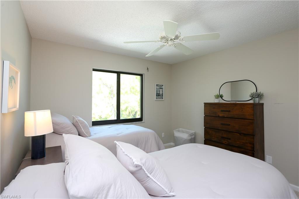 5733 Deauville Circle, Unit G308 Naples, FL 34112 - Photo 12 of 50 a bedroom with a bed and a dresser