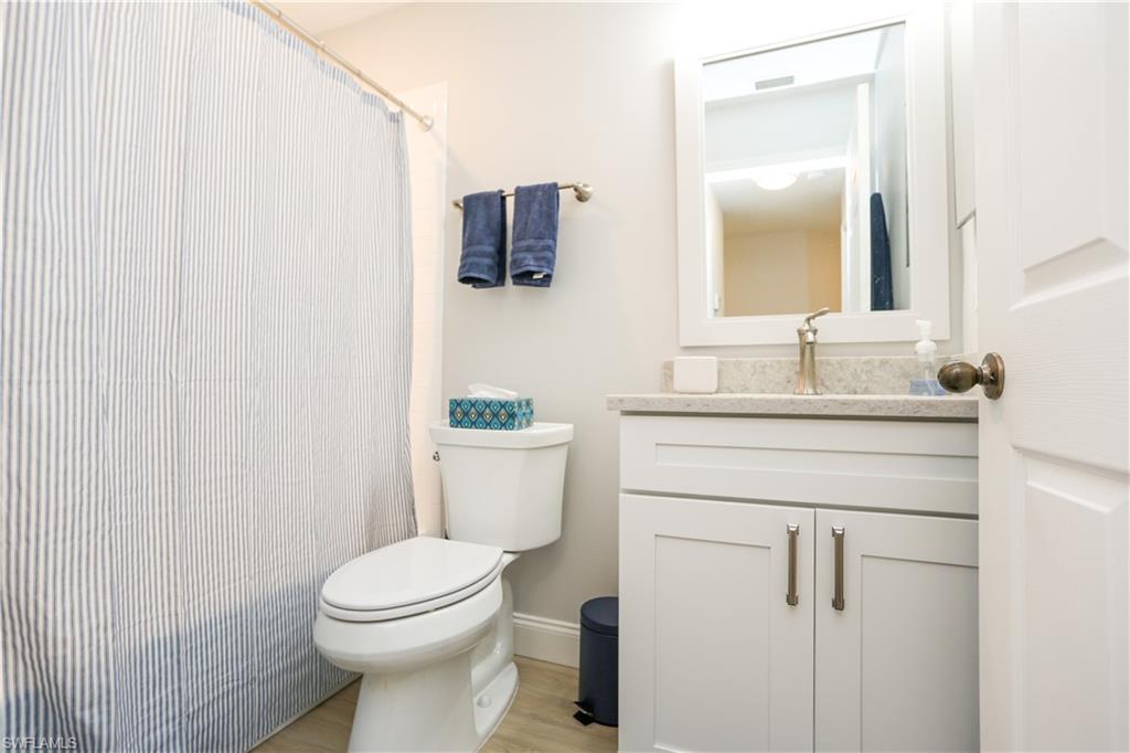 5733 Deauville Circle, Unit G308 Naples, FL 34112 - Photo 13 of 50 a bathroom with a toilet sink and mirror