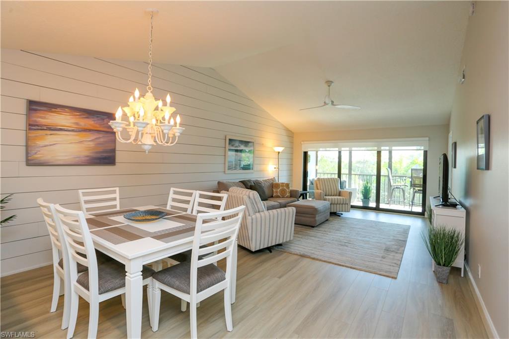 5733 Deauville Circle, Unit G308 Naples, FL 34112 - Photo 15 of 50 a view of a dining room with furniture wooden floor and chandelier
