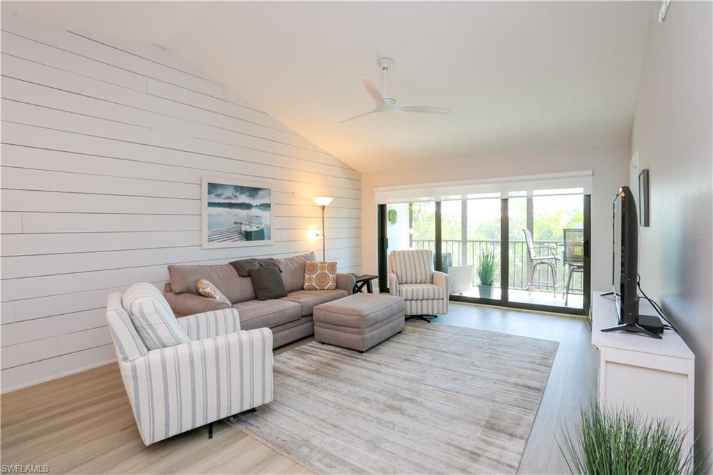 5733 Deauville Circle, Unit G308 Naples, FL 34112 - Photo 16 of 50 a living room with furniture and a flat screen tv
