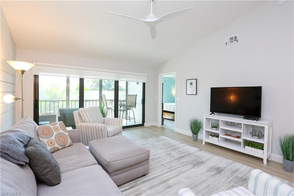 5733 Deauville Circle, Unit G308 Naples, FL 34112 - Photo 19 of 50 a living room with furniture and a flat screen tv