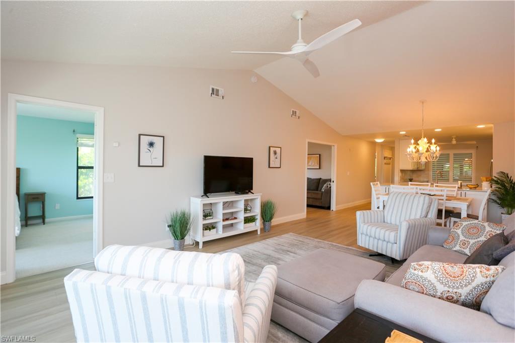 5733 Deauville Circle, Unit G308 Naples, FL 34112 - Photo 23 of 50 a living room with furniture and a flat screen tv
