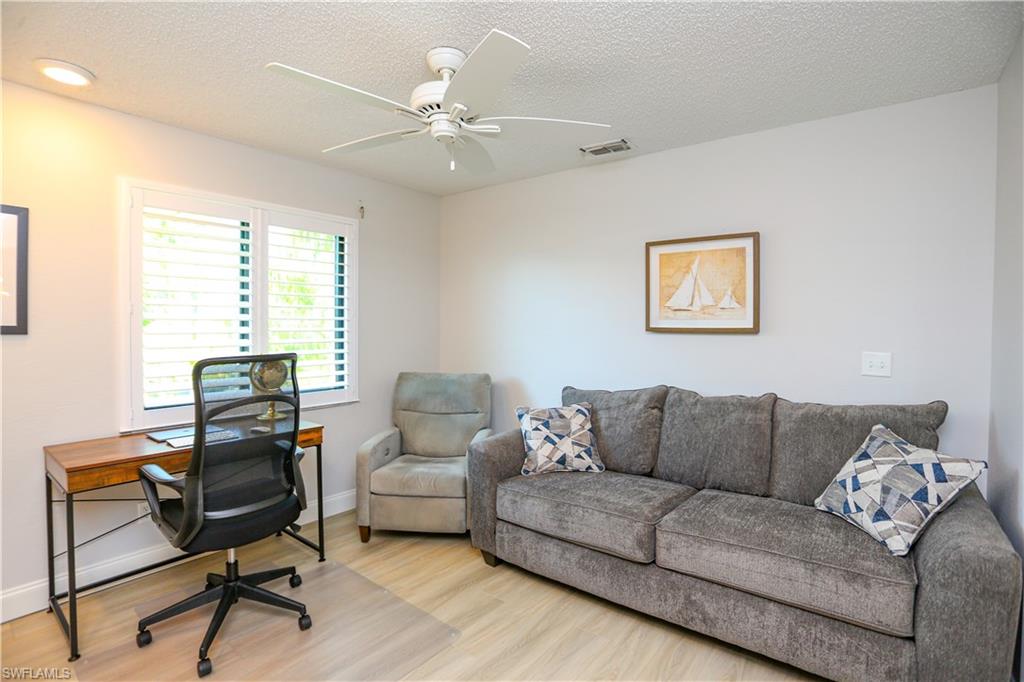 5733 Deauville Circle, Unit G308 Naples, FL 34112 - Photo 25 of 50 a living room with furniture and a window