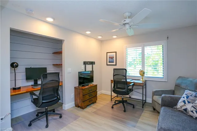 a view of a workspace with furniture and a window