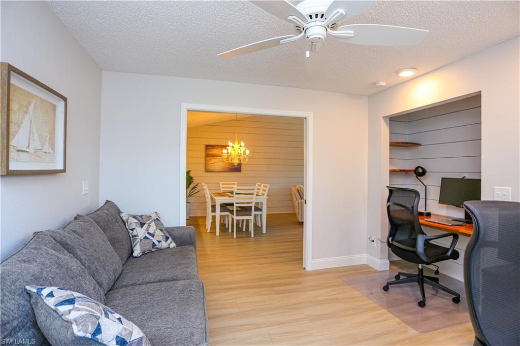 5733 Deauville Circle, Unit G308 Naples, FL 34112 - Photo 27 of 50 a living room with furniture and a chandelier