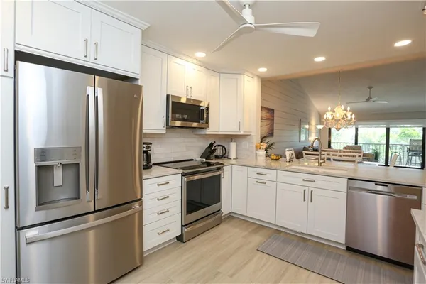 a kitchen with white cabinets and stainless steel appliances