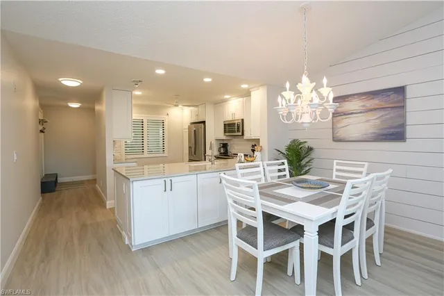 a kitchen with stainless steel appliances kitchen island granite countertop a table and chairs in it