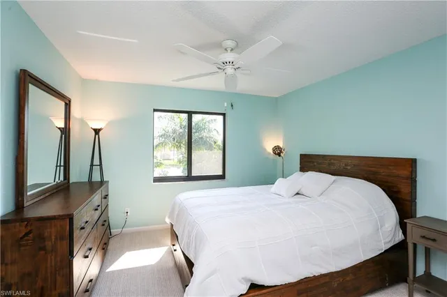 a bedroom with a bed a chandelier and a flat tv
