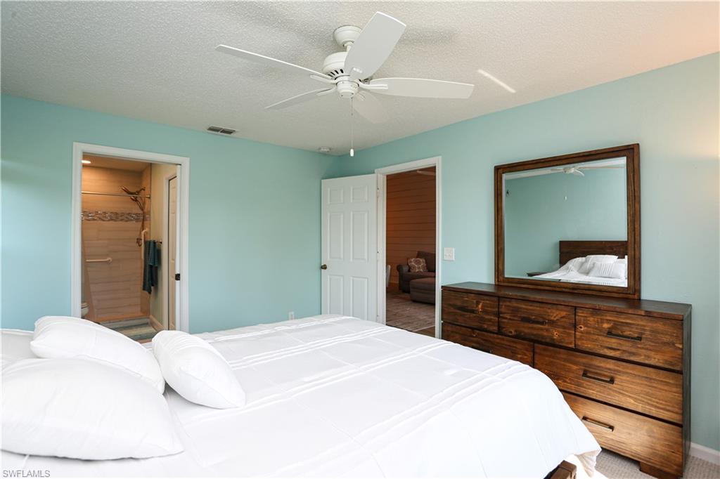 5733 Deauville Circle, Unit G308 Naples, FL 34112 - Photo 43 of 50 a bedroom with a bed and a dresser