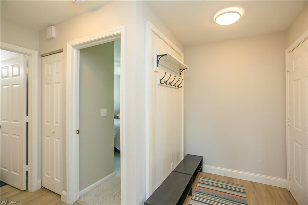 5733 Deauville Circle, Unit G308 Naples, FL 34112 - Photo 6 of 50 a view of a hallway with wooden floor and entryway