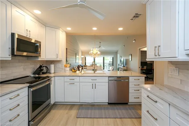 a kitchen with stainless steel appliances granite countertop a stove top oven a sink dishwasher and a refrigerator with wooden cabinets