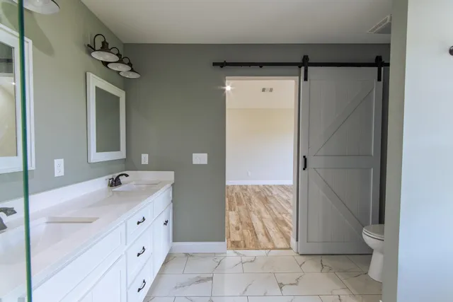 a bathroom with a double vanity sink toilet and shower