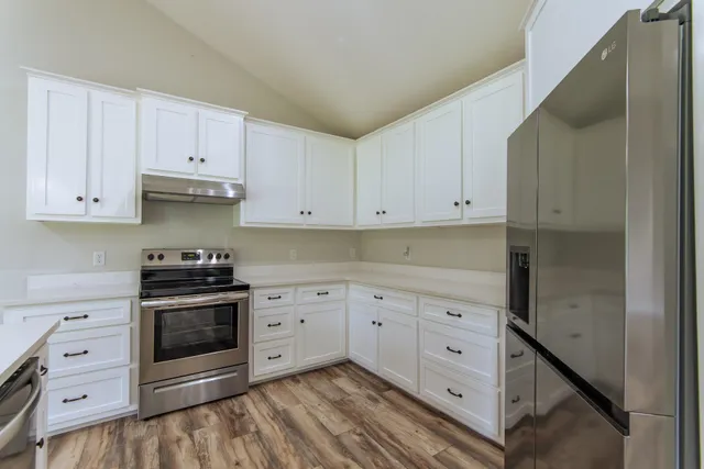 a kitchen with cabinets stainless steel appliances and a sink