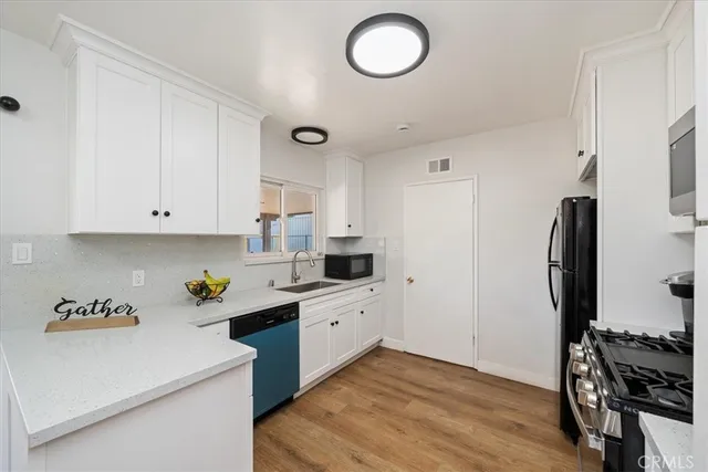 a kitchen with a sink stainless steel appliances and cabinets