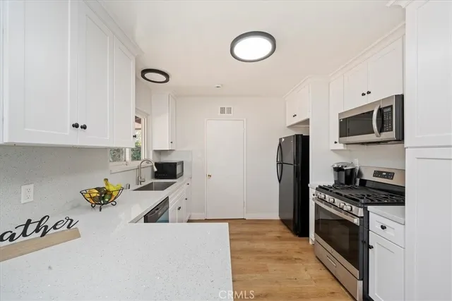 a kitchen with stainless steel appliances granite countertop a refrigerator stove top oven a sink and dishwasher