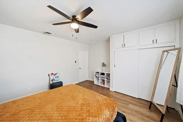 a bedroom with a bed and a refrigerator