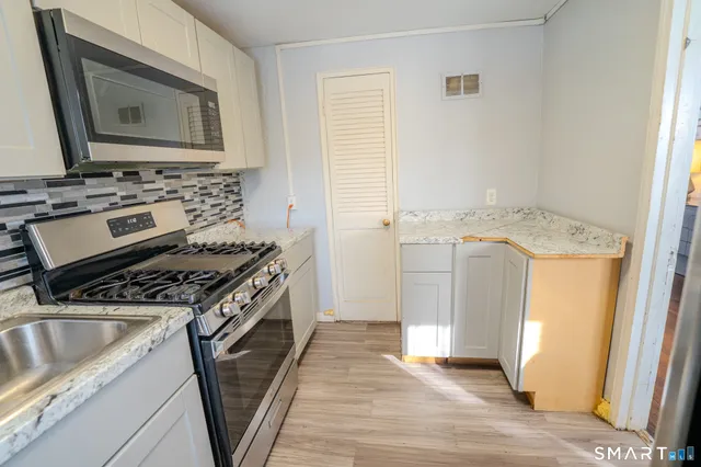 a kitchen with a stove sink and cabinets