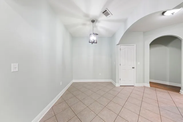a view of empty room with wooden floor and ceiling fan