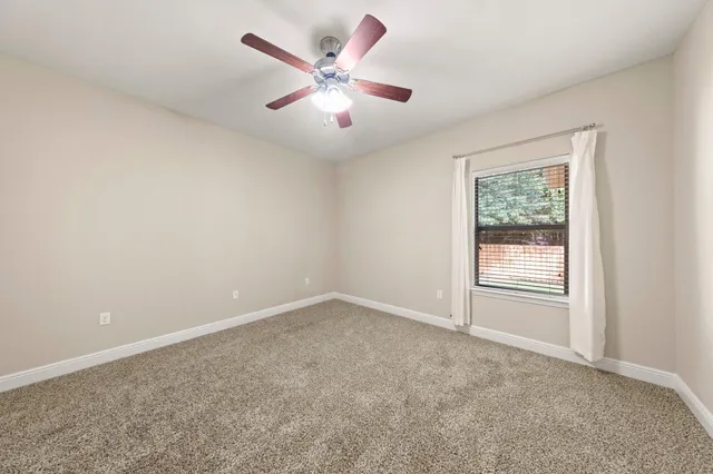 a bathroom with a granite countertop sink a toilet and a mirror