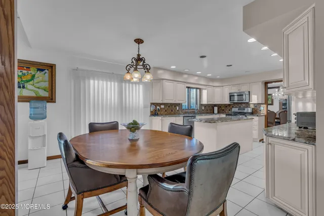 a kitchen with kitchen island a dining table and chairs