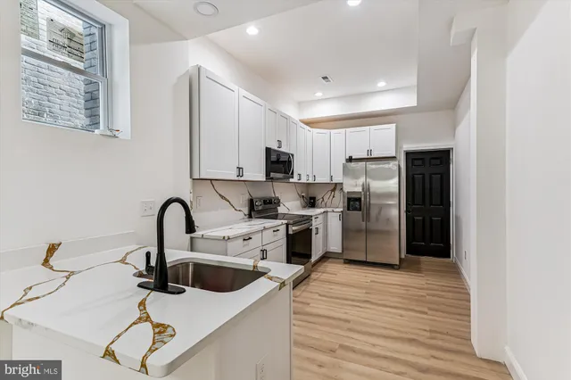 a kitchen with stainless steel appliances a refrigerator sink and cabinets