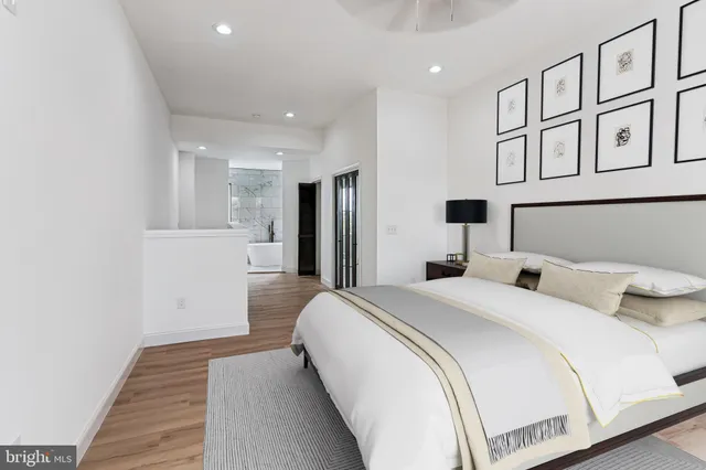 a spacious bedroom with a bed and wooden floor