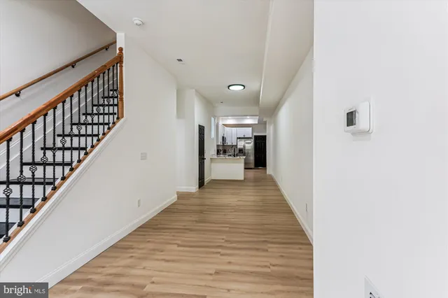a view of a hallway with wooden floor and staircase