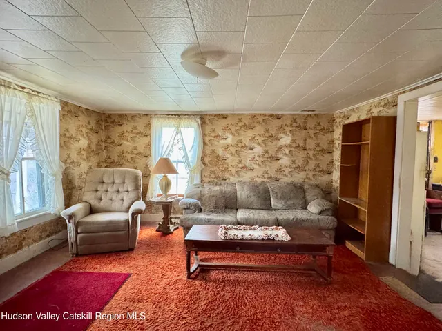 a living room with furniture lamp and large window