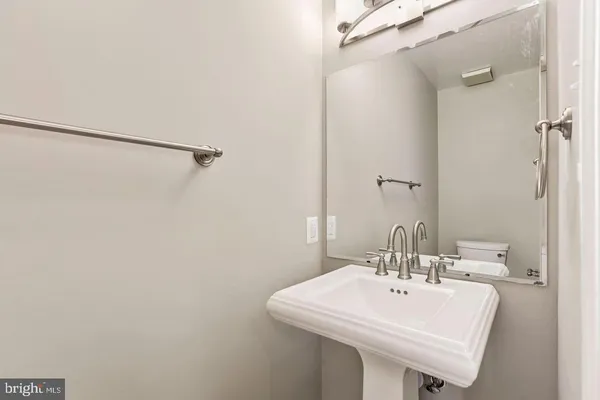 a white sink under a bathroom mirror