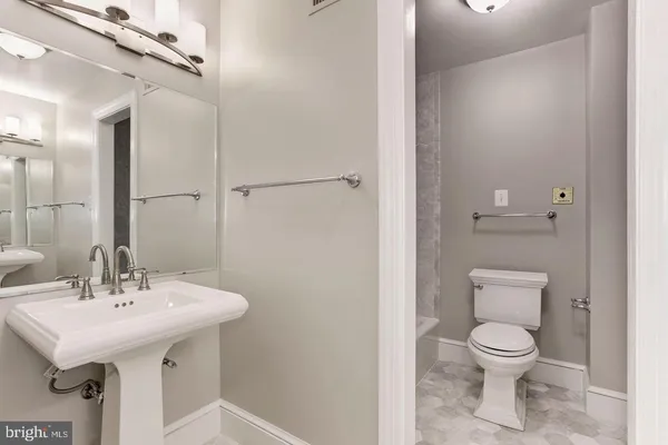 a bathroom with a toilet a sink and a mirror