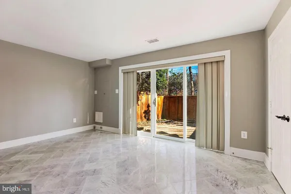 a view of an empty room with wooden floor and windows