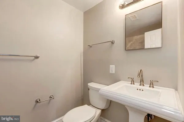 a bathroom with a toilet a sink and mirror
