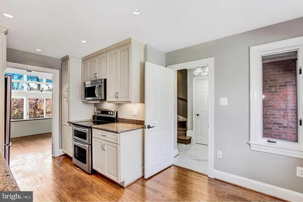 a kitchen with stainless steel appliances a stove top oven a sink a refrigerator a window