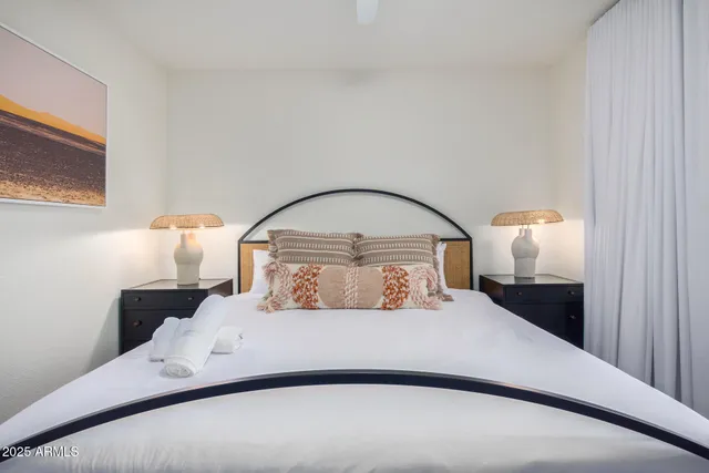 a bedroom with a bed and a painting on the wall