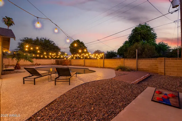 a view of a swimming pool with a patio and a yard
