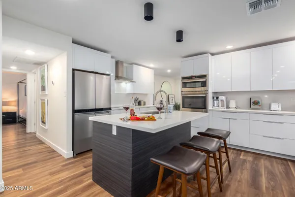 a kitchen with stainless steel appliances a stove refrigerator sink and microwave
