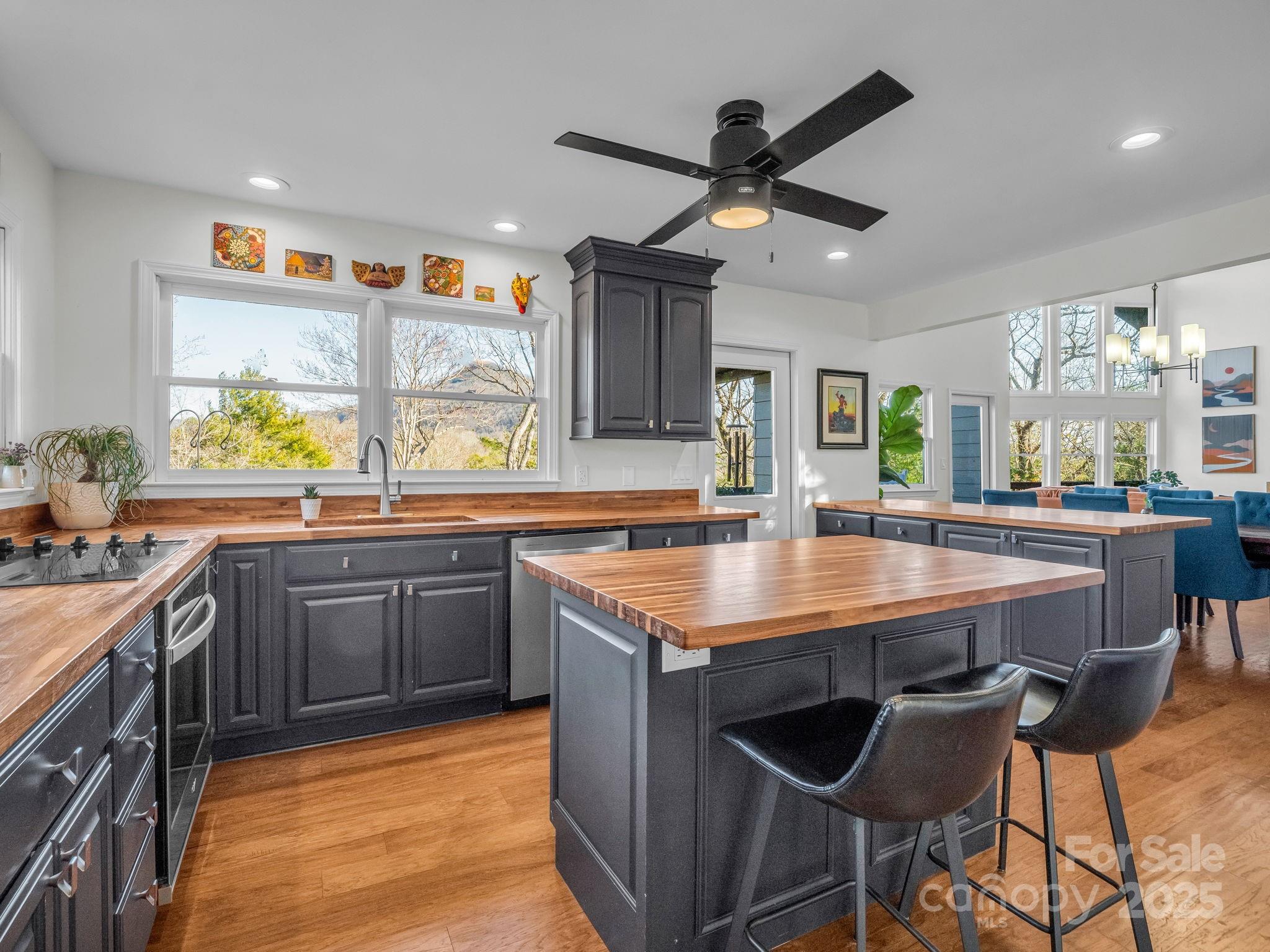158 Rock Spring Road Lake Lure, NC 28746 - Photo 8 of 48 a kitchen with stainless steel appliances granite countertop wooden cabinets a stove a sink a dining table and chairs