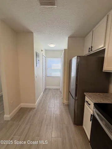 a kitchen with a refrigerator and a stove top oven