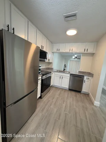 a kitchen with stainless steel appliances a refrigerator sink and cabinets