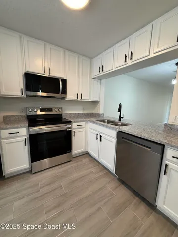 a kitchen with cabinets stainless steel appliances and a sink