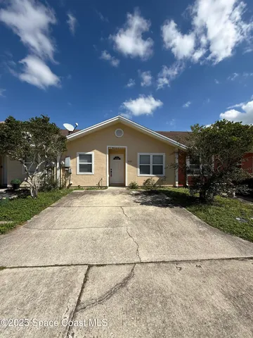 a view of a house with a yard and large tree