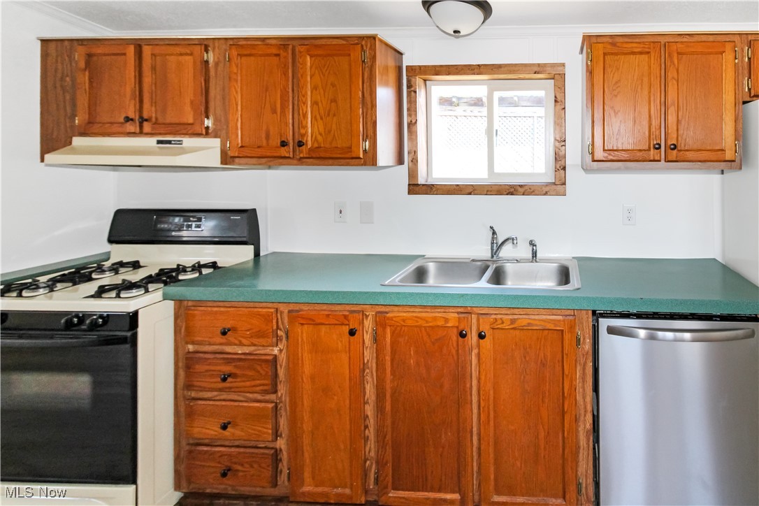 265 Meachem Road, Unit 41 Port Clinton, OH 43452 - Photo 19 of 33 Kitchen featuring gas range oven, under cabinet range hood, stainless steel dishwasher, a sink, and brown cabinetry